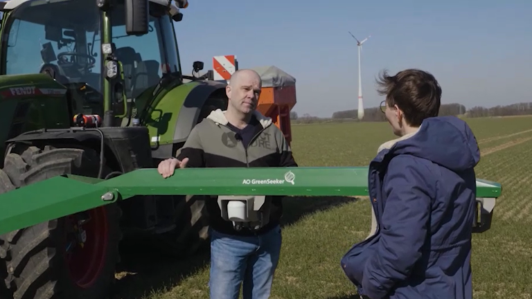 Landwirt Thorsten Schmidt mit Fendt Moderatorin vor seinem Traktor im Feld